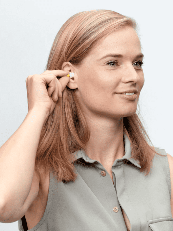 Kvinde indsætter Flykit øreprop i øret