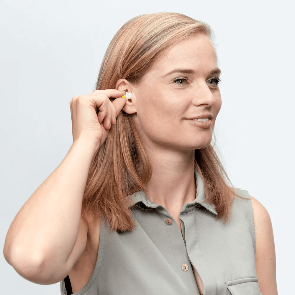Kvinde indsætter Flykit øreprop i øret