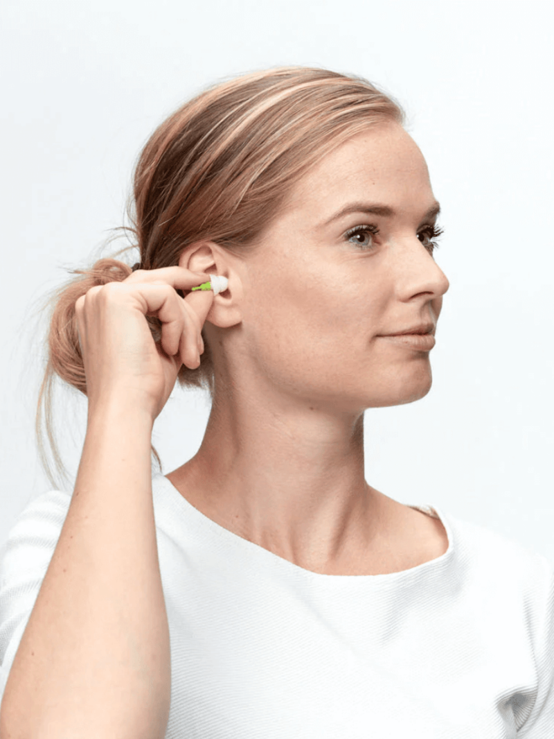 Kvinde sætter Alpine SleepSoft øreprop i øret
