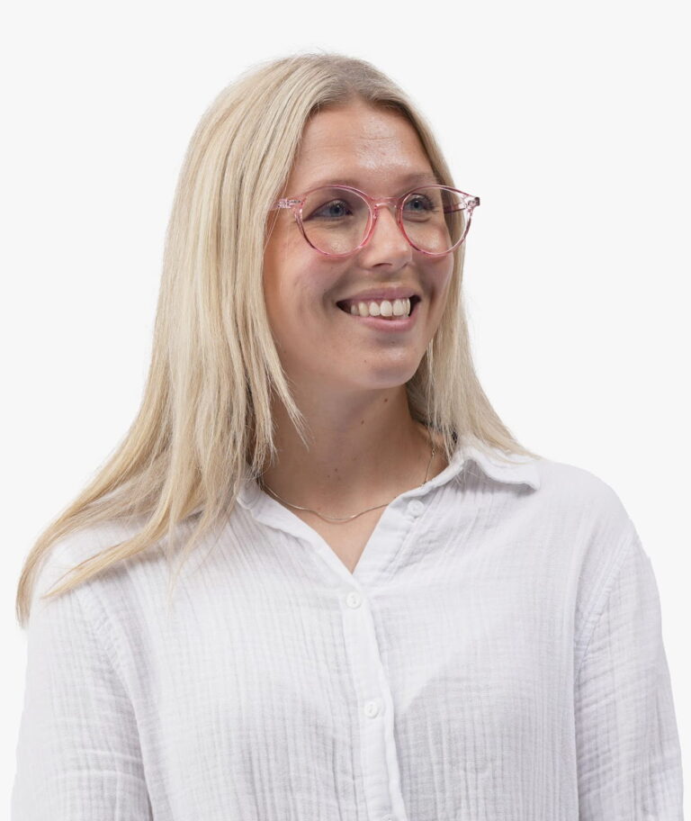 Smilende blond kvinde med runde pink briller og hvid skjorte, kigger mod højre